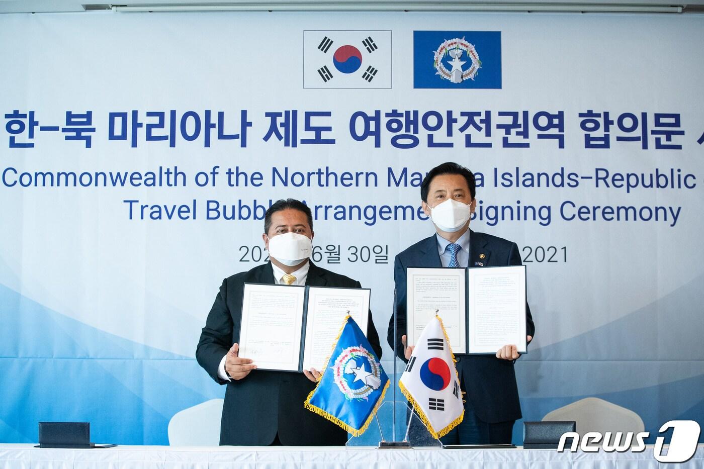 본문 이미지 - 황성규 국토교통부 제2차관(오른쪽)과 토레스 안토니 데 레온 구에레로 북마리아나 주지사가 30일 서울 중구 롯데호텔에서 열린 한-북 마리아나 제도 여행안전권역 합의문 서명식에서 서명을 마친 합의문을 들고 포즈를 취하고 있다. 국토교통부는 이날 사이판과 '트래블 버블' 합의문에 서명했다. 트래블 버블이란 방역관리에 대한 신뢰가 확보된 국가간 격리를 면제, 자유로운 여행을 허용하는 것을 뜻한다. 2021.6.30/뉴스1 ⓒ News1 유승관 기자
