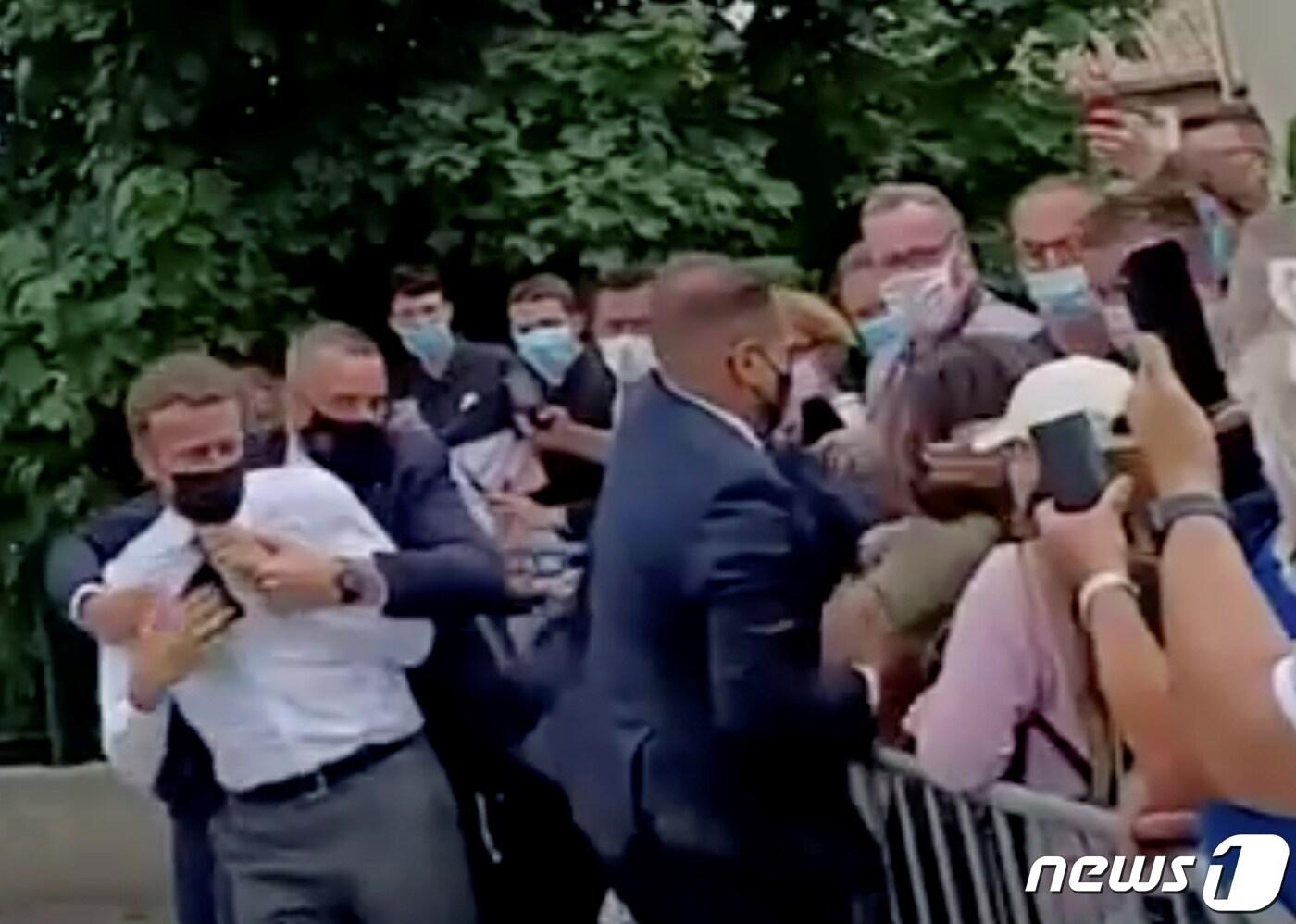 에마뉘엘 마크롱 프랑스 대통령이 2021년 6월8일(현지시간) 지방 순회를 하던 중 탱레흐미타주 거리에서 20대 남성에게 뺨을 맞은 뒤 몸을 피하고 있다. ⓒ 로이터=뉴스1 ⓒ News1 우동명 기자