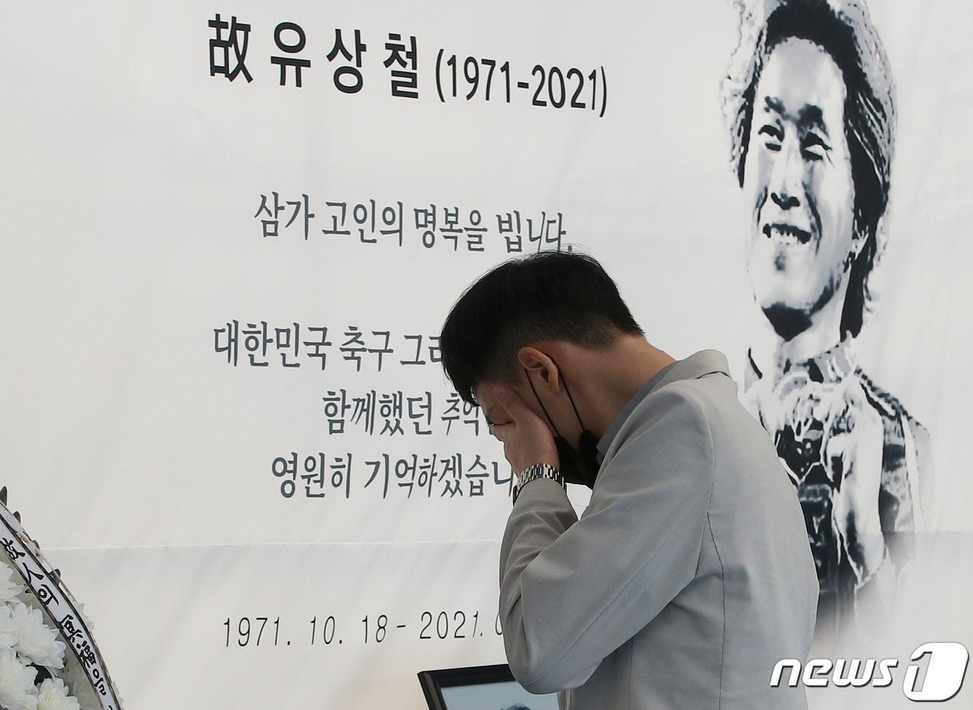 본문 이미지 - 9일 울산 문수축구경기장에 고(故) 유상철 전 감독을 애도하기 위한 추모 공간이 마련된 가운데 유상철 감독의 팬인 홍지수씨가 고인의 사진 앞에서 눈물을 흘리고 있다. 2021.6.9/뉴스1 ⓒ News1 윤일지 기자