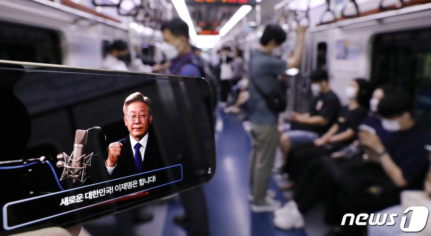 1일 오전 한 시민이 지하철 1호선 안에서 더불어민주당 대선 주자인 이재명 경기지사의 제20대 대통령 선거 출마선언 라이브 방송을 스마트폰으로 시청하고 있다. 2021.7.1/뉴스1 ⓒ News1 김진환 기자