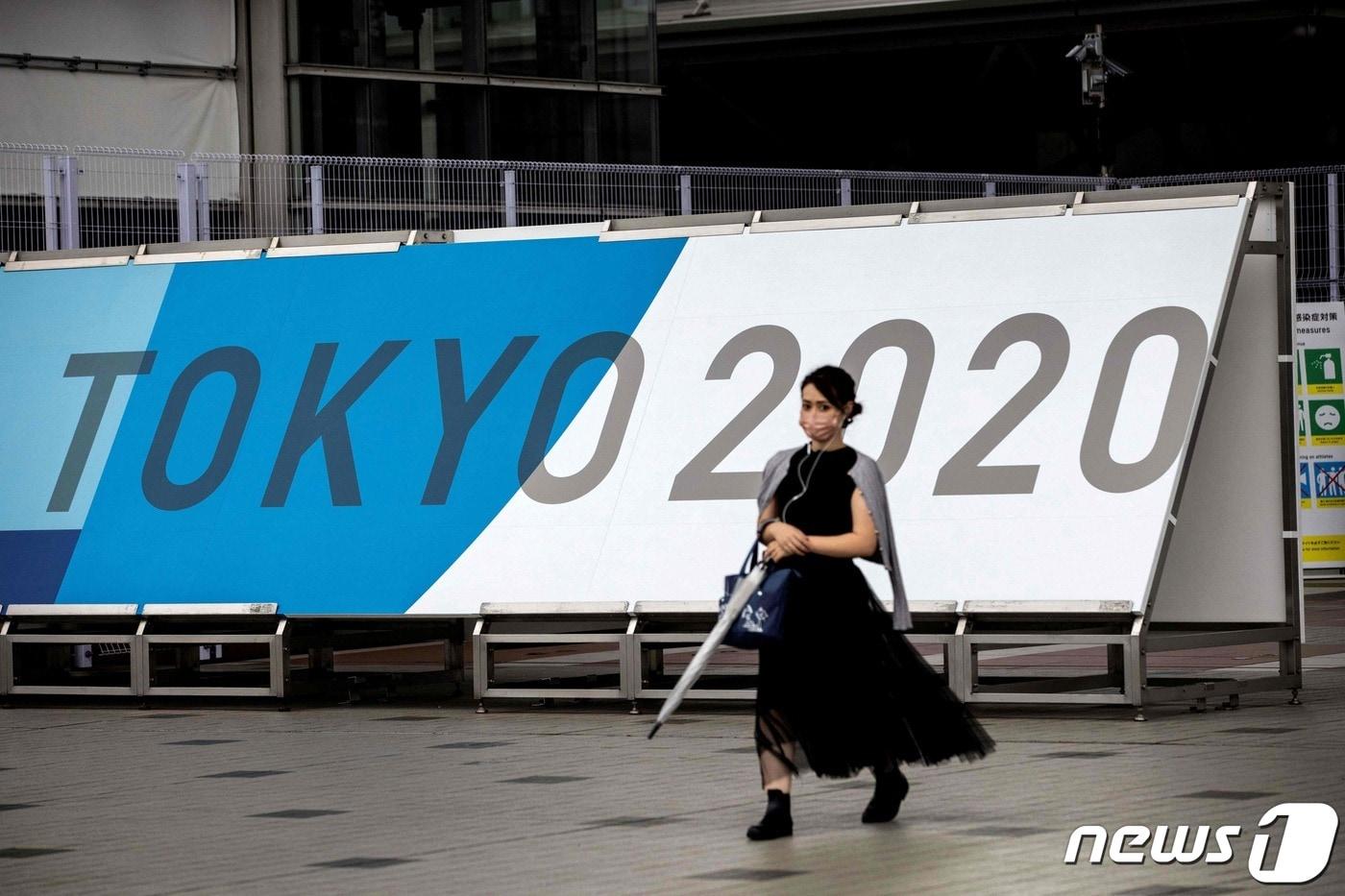 9일 일본 도쿄에서 마스크를 쓴 한 여성이 2020 도쿄올림픽 광고판 앞을 지나고 있다. 도쿄올림픽 개막식은 오는 23일 열린다. ⓒ AFP=뉴스1 ⓒ News1 최종일 기자