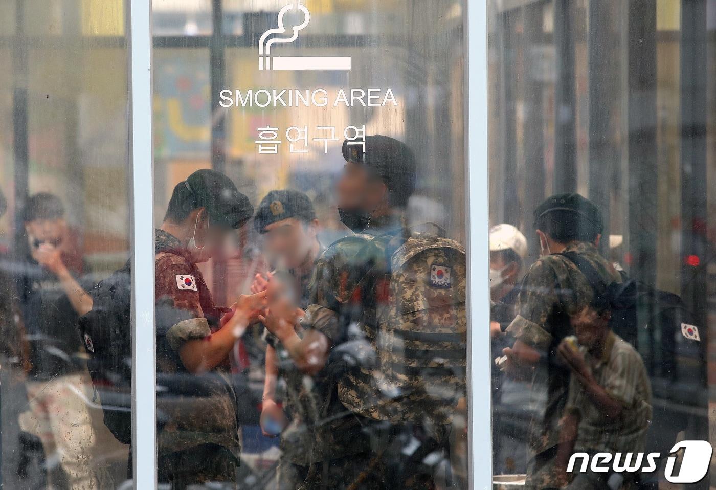 본문 이미지 - 서울역 광장에 마련된 중구 임시 선별검사소 옆 흡연구역에서 군인들이 담배를 피고 있다. ⓒ News1