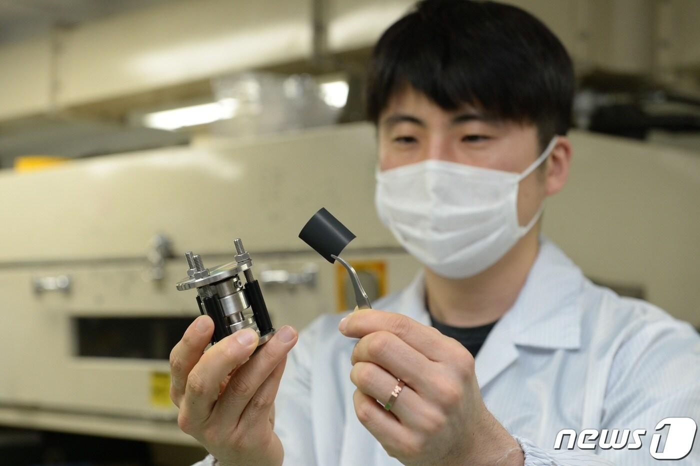 ETRI 연구진이 ETRI, DGIST가 공동개발한 전고체 이차전지 양극 소재를 관찰하고 있다.&#40;사진제공:ETRI&#41;ⓒ 뉴스1