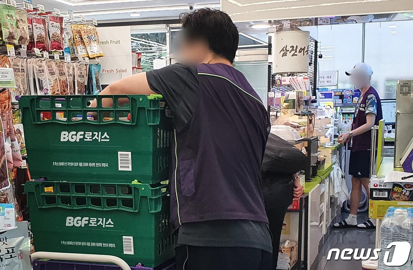 본문 이미지 - 2022년 적용 최저임금이 시간당 9,160원으로 결정된 13일 서울시내 한 편의점에서 직원들이 업무를 보고 있다.  2021.7.13/뉴스1 ⓒ News1 유승관 기자