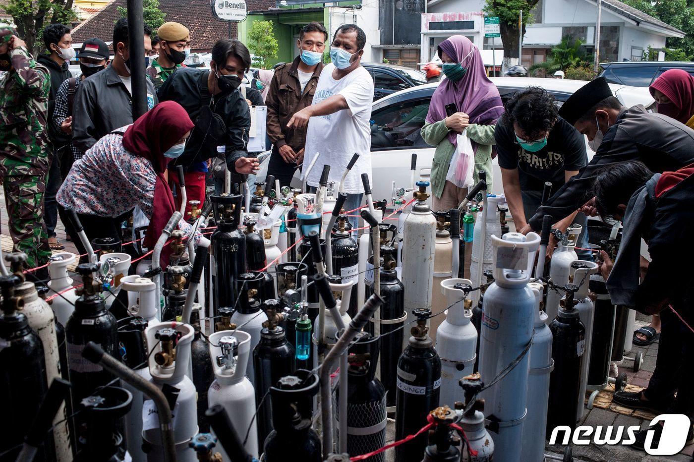 14일(현지시간) 인도네시아 욕야카르타에서 주민들이 코로나19 환자용 산소통을 충전하기 위해 모여 있다. ⓒ AFP=뉴스1 ⓒ News1 우동명 기자
