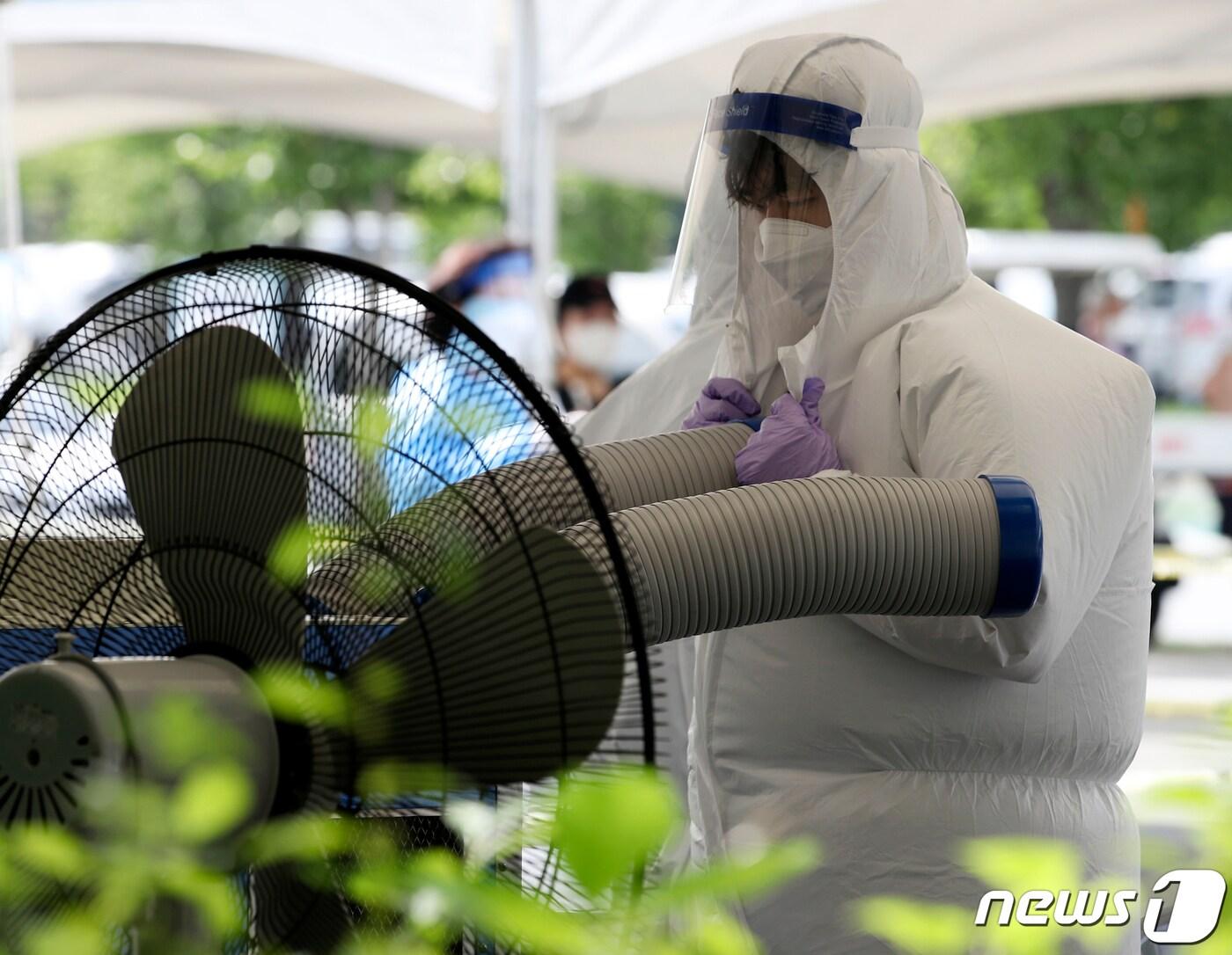 본문 이미지 - 울산지역에 8일째 폭염주의보가 이어지고 있는 16일 오후 울산 남구 임시 선별검사소에서 의료진이 냉풍기 바람을 쐬며 더위를 식히고 있다. 2021.7.16/뉴스1 ⓒ News1 윤일지 기자