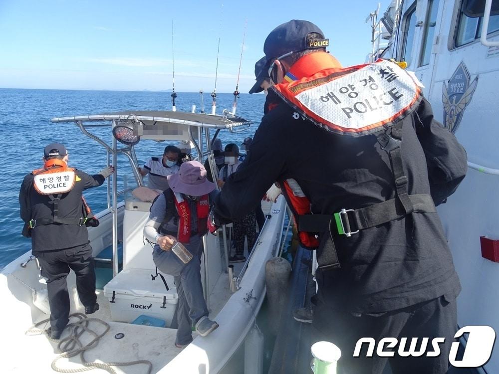 본문 이미지 - 군산해경이 레저보트 이용객 6명을 해경함정에 옮겨 싣고 있다.ⓒ 뉴스1