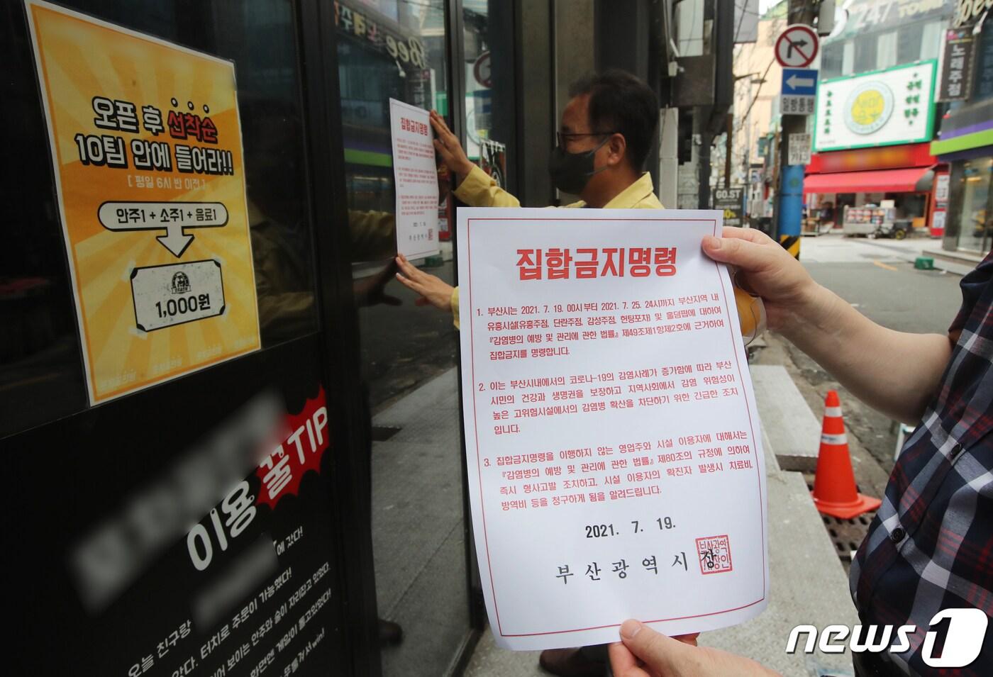본문 이미지 - 부산 부산진구 서면에서 부산진구청 공무원들이 한 업소에 집합금지 행정명령문을 부착하고 있다.2021.7.19/뉴스1 ⓒ News1 여주연 기자