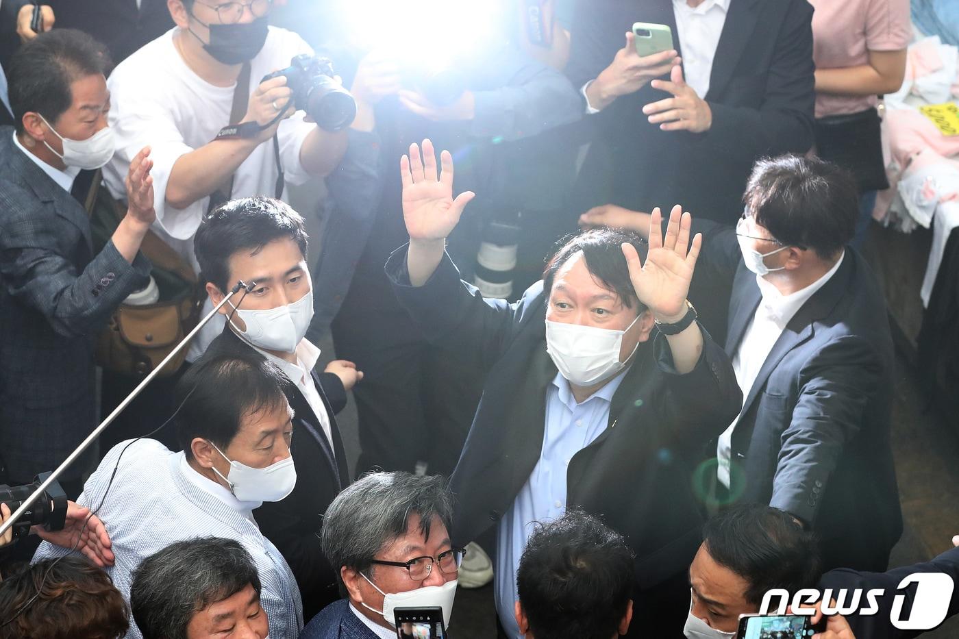 야권 대선주자인 윤석열 전 검찰총장이 20일 낮 대구 서문시장을 찾아 상가 연결통로에 환영 나온 시민들을 향해 손을 흔들어 인사하고 있다. 2021.7.20/뉴스1 ⓒ News1 공정식 기자