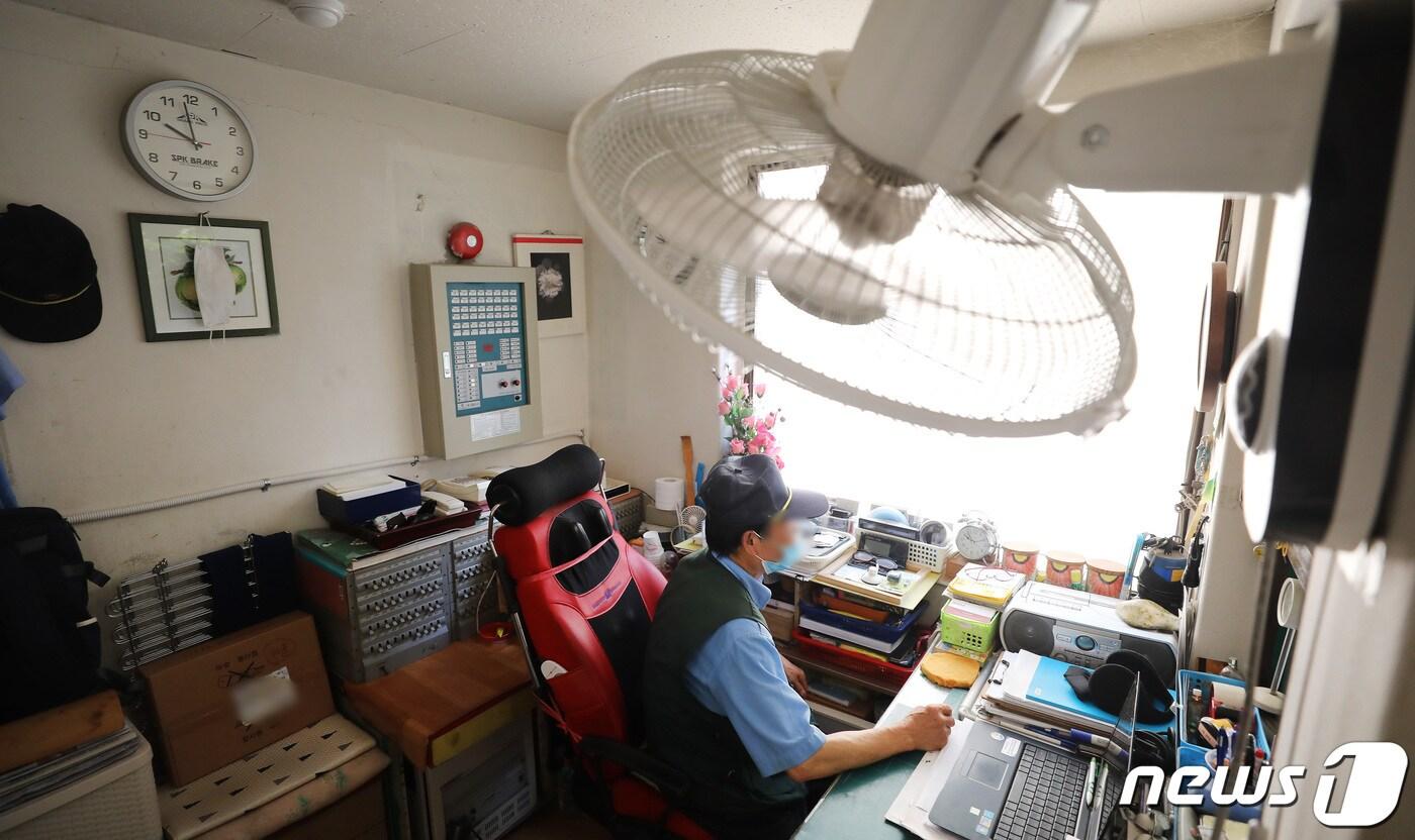 본문 이미지 - 서울 시내 아파트 단지 경비실에서 한 경비원이 에어컨 없이 선풍기로 더위를 견디고 있다. 2021.7.23/뉴스1 ⓒ News1 임세영 기자