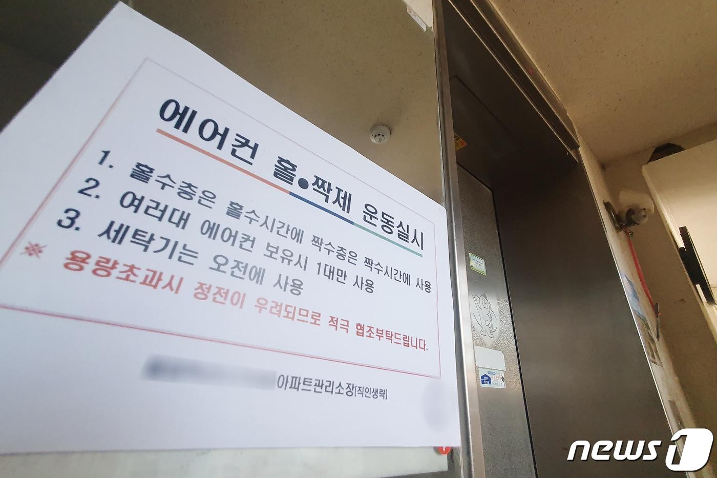본문 이미지 - 25일 서울의 한 아파트에 정전 사태 방지를 위한 에어컨 홀·짝제 운동 공고문이 부착돼 있다. 2021.7.25 ⓒ 뉴스1 민경석 기자