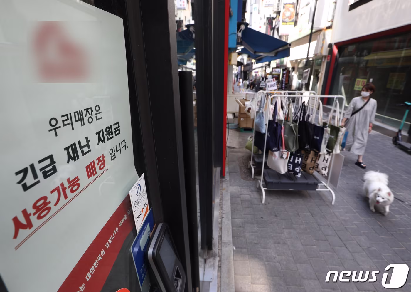 본문 이미지 - 25일 서울 명동거리의 한 매장에 재난지원금 결제가 가능하다는 안내문이 붙어 있다. 2021.7.25/뉴스1 ⓒ News1 신웅수 기자