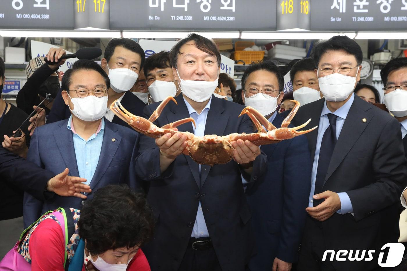본문 이미지 - 윤석열 전 검찰총장이 27일 오후 부산 중구 자갈치시장을 찾아 상인이 건넨 대게를 들어보이고 있다. 2021.7.27/뉴스1 ⓒ News1 여주연 기자