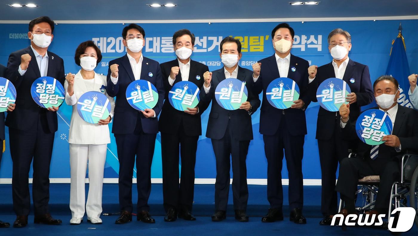 본문 이미지 - 더불어민주당 송영길 대표와 대선 예비후보들이 28일 서울 여의도 중앙당사에서 열린 제20대 대통령선거 '원팀' 협약식에서 '원팀' 팻말을 들고 포즈를 취하고 있다. 왼쪽부터 송영길 대표, 추미애, 박용진, 이낙연, 정세균, 김두관, 이재명 후보, 이상민 선거관리위원장. 2021.7.28/뉴스1 ⓒ News1 구윤성 기자