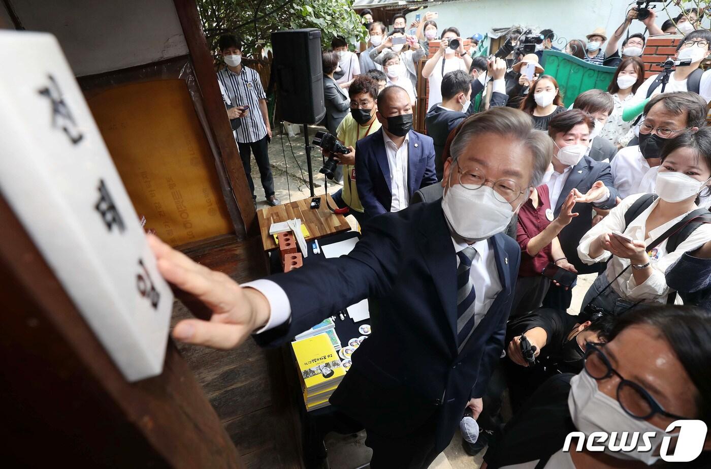 2021년 7월 당시 더불어민주당 대권 주자였던 이재명 경기도지사가 대구 중구 남산동 전태일 열사 옛집을 찾아 &#39;전태일의친구들&#39;과 시민이 달아놓은 문패를 어루만지고 있다. &#40;사진은 기사 내용과 무관함&#41; 2021.7.30/뉴스1 ⓒ News1 공정식 기자