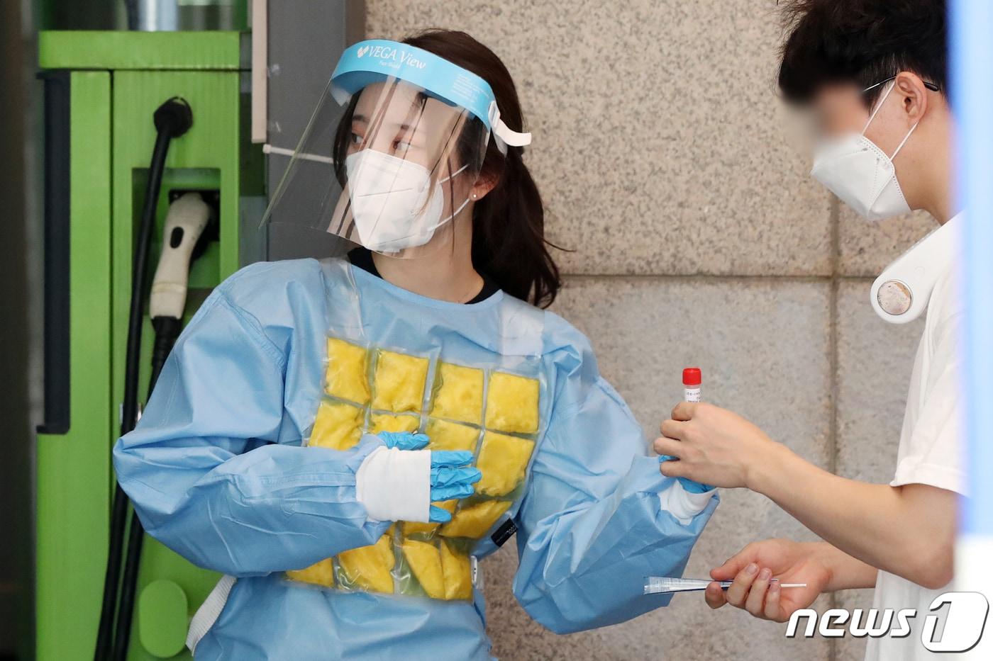 본문 이미지 - 서울 지역 낮 최고 기온이 35도에 육박해 무더운 날씨를 보인 30일 서울 동작구 보건소에 마련된 신종 코로나바이러스 감염증(코로나19) 선별진료소에서 의료진이 아이스팩 조끼를 입고 무더위를 극복하고 있다. 2021.7.30/뉴스1 ⓒ News1 민경석 기자