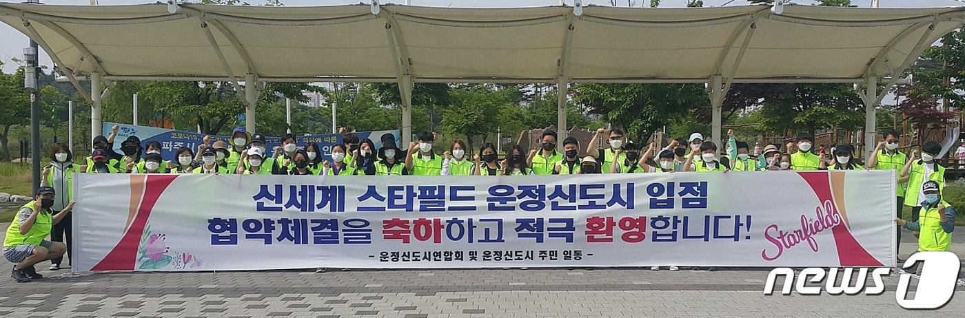 본문 이미지 - 운정신도시연합회 소속 회원들이 파주 스타필드 입점을 환영하는 현수막을 들고 있다. (운정연 제공) ⓒ 뉴스1