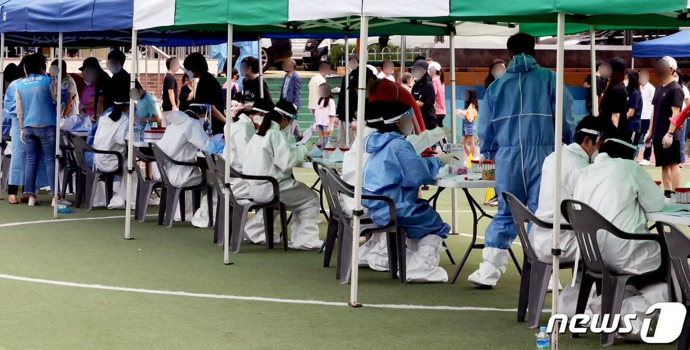 본문 이미지 - 인천 미추홀구 소재 인주초등학교 6학년 3개반에서 신종 코로 나 바이러스 감염증(코로나19) 확진자 23명이 발생했다. 방역당국은 학교 운동장에 선별진료소를 설치하고 전교생 및 학부모, 교직원 등 총 3000여 명에 대해 검사를 진행하기로 했다. 한 학생이 6일 오전 인천시 미추홀구 인주초등학교에서 진단검사를 받기 위해 대기하고 있다. 2021.7.6/뉴스1 ⓒ News1 정진욱 기자