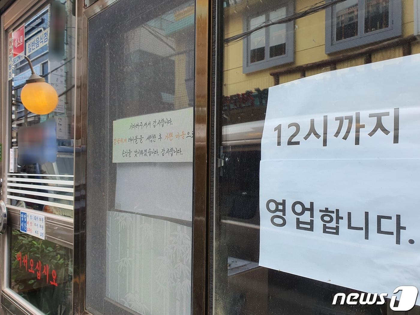 본문 이미지 - 지난 7월8일 사회적 거리두기 2단계 격상 당시 부산 부산진구 서면 번화가의 한 음식점 입구에 '밤 12시까지 영업'을 알리는 안내 문구가 부착돼 있는 모습. ⓒ News1 DB