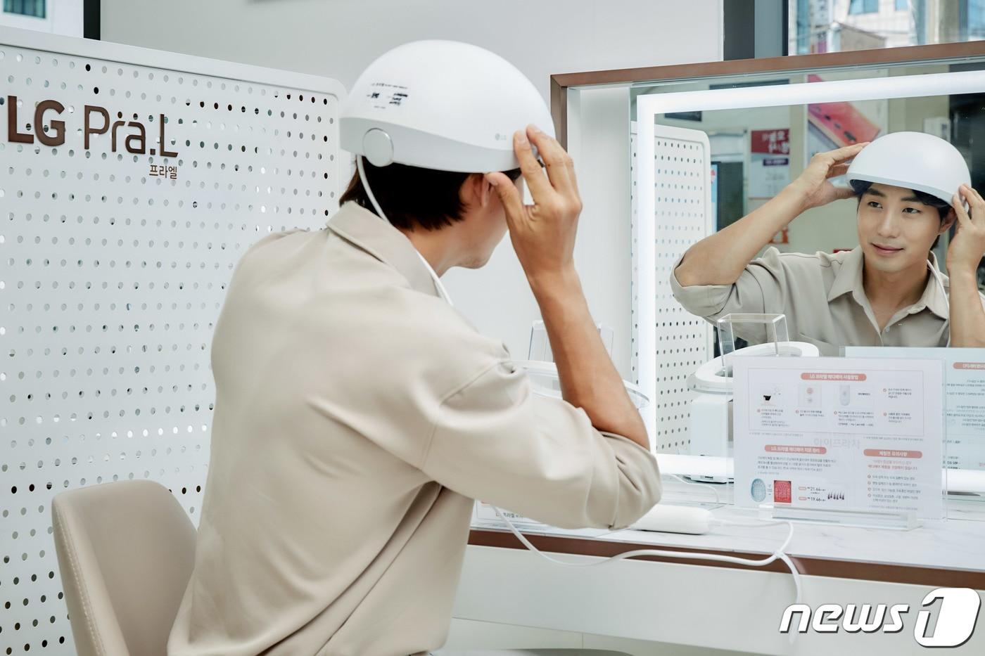 한 모델이 서울 관악구 LG베스트샵 봉천점에 설치돼 있는 'LG 프라엘 메디헤어' 전용 체험공간에서 메디헤어를 착용해보고 있다.(LG전자 제공) 2021.8.1/뉴스1
