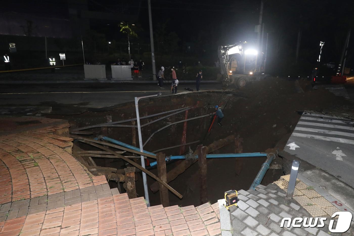 11일 오후 10시50분쯤 대구 동구 괴전동 한국농수산식품유통공사 안심비축기지 앞 도로(반야월 연꽃단지·안심차량기지사업소 입구) 주변에서 교통사고를 처리하던 경찰관이 길이 10ｍ, 깊이 5ｍ 규모의 싱크홀(땅 꺼짐)을 발견했다. 12일 오전 2시쯤 경찰과 관계기관이 싱크홀 현장 주변을 통제한 뒤 중장비를 동원해 응급복구를 진행하고 있다. 2021.8.12/뉴스1 ⓒ News1 공정식 기자