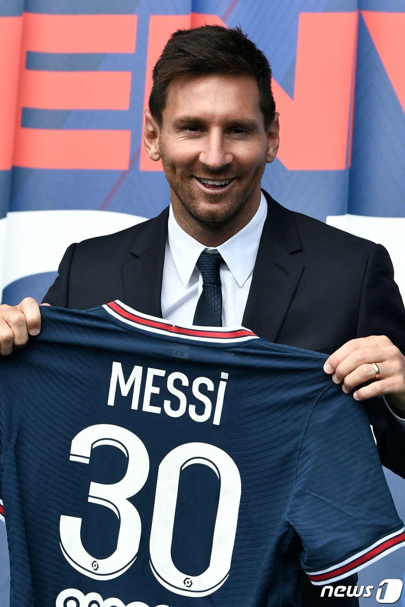 본문 이미지 - 리오넬 메시가 11일(현지 시간) 파리 파르크 데 프랭스 스타디움에서 프랑스 리그1의 파리 생제르맹(PSG)과 2+1년 계약을 체결한 뒤 등번호 30번을 새긴 유니폼을 들고 포즈를 취하고 있다. ⓒ AFP=뉴스1