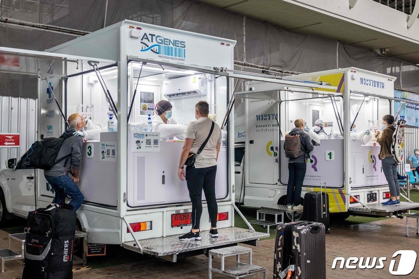 본문 이미지 - 11일 (현지시간) 태국 푸켓 공항에 마련된 코로나19 검사소에서 의료진들이 승객들에게 면봉 검사를 하고 있다. (자료 사진) ⓒ AFP=뉴스1 ⓒ News1 우동명 기자