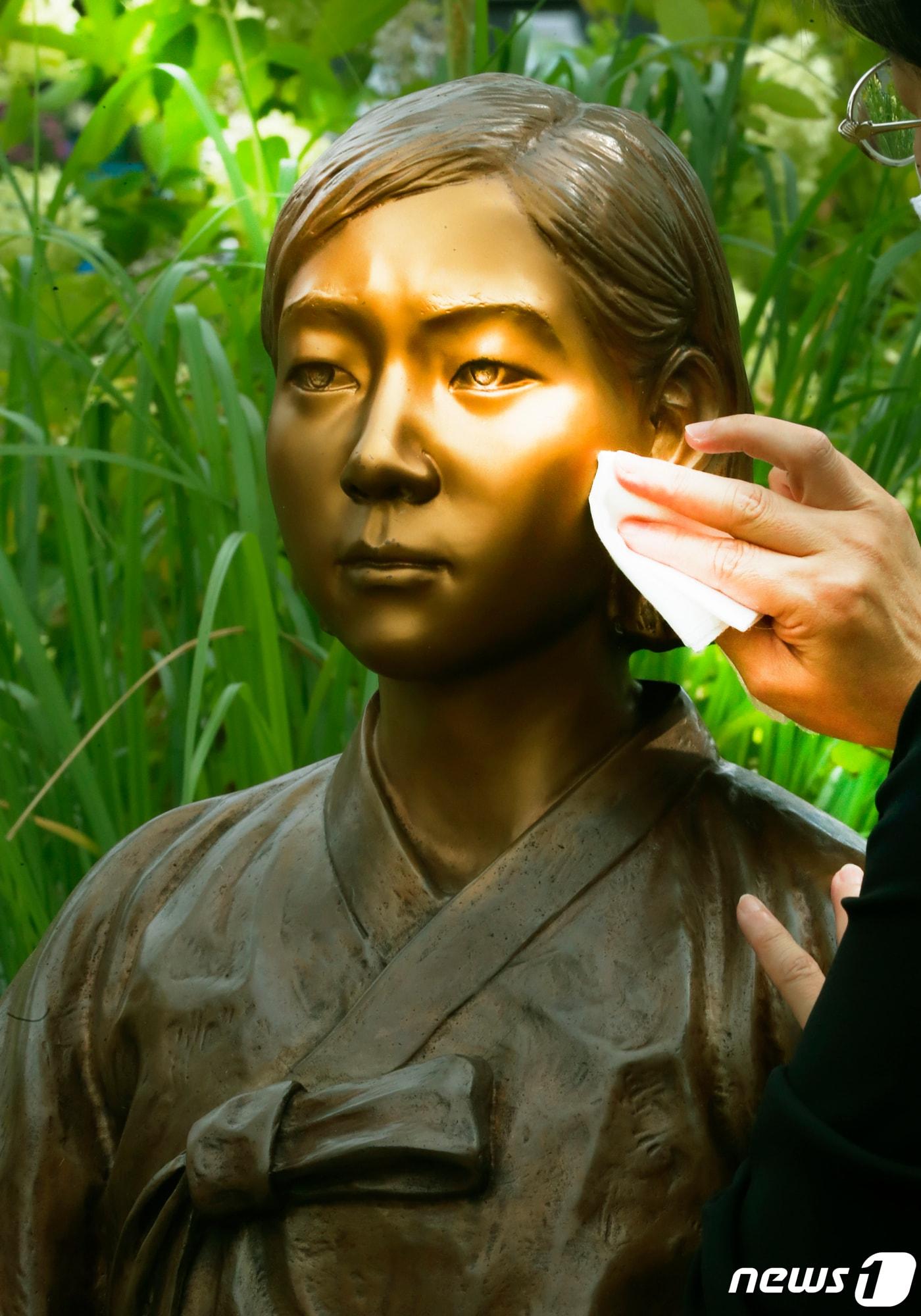 본문 이미지 - 일본군 위안부 피해자 기림의 날을 하루 앞둔 지난 13일 오전 서울 송파구 가락동 송파 평화의 소녀상 정원에서 구청 관계자들이 청소하고 있다. (송파구청 제공) /뉴스1 ⓒNews1