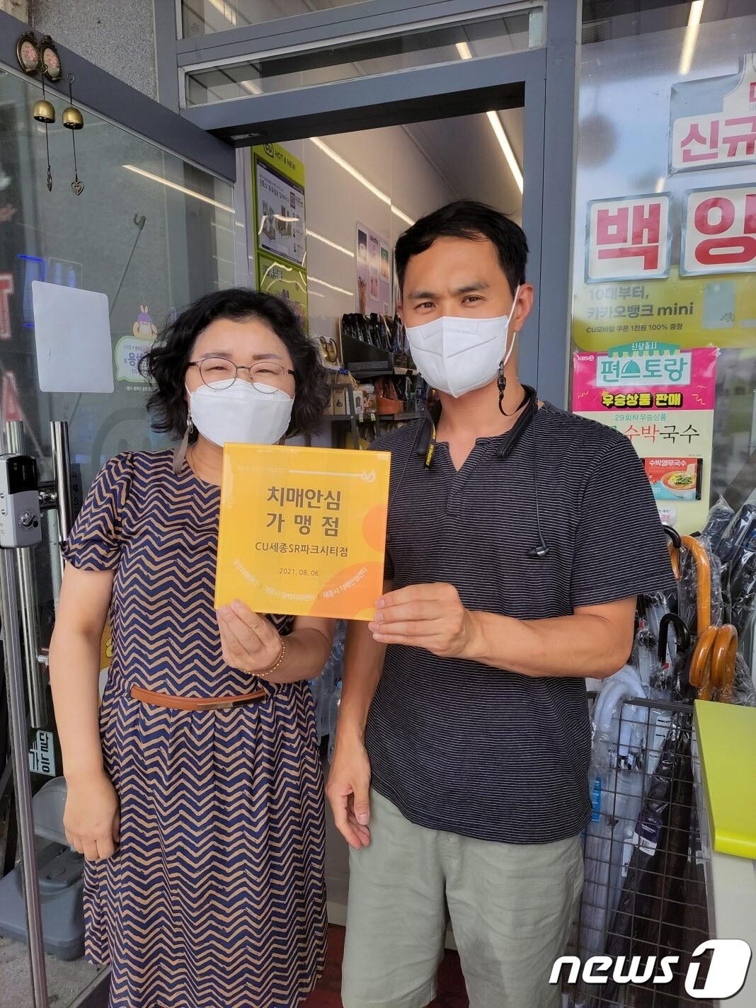 본문 이미지 - 세종시보건소 치매안심센터는 CU 세종1번국도점과 CU 세종SR파크시티점 2곳을 치매안심가맹점으로 지정했다. 전은정 치매안심센터장이 박선재 CU 세종1번국도점 대표에게 지정 인증서를 전달한 뒤 기념촬영을 하고 있다. (세종시 제공) /2021.8.18/ⓒ 뉴스1