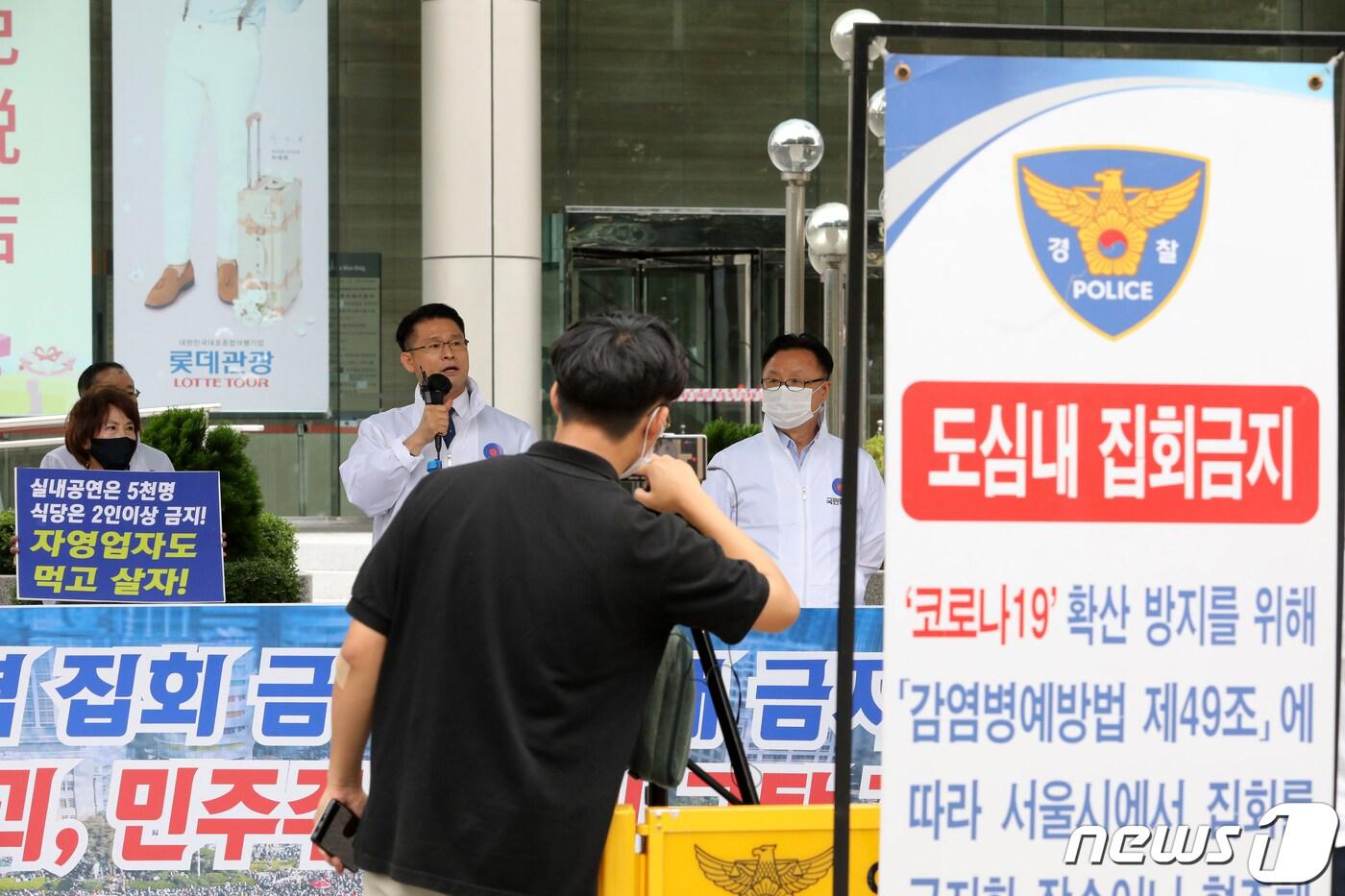 지난 2일 정부 규탄 기자회견을 하는 국민혁명당 관계자들 앞으로 '도심 내 집회금지'를 알리는 경찰 현수막이 걸려있다. 2021.8.2/뉴스1 ⓒ News1 이승배 기자