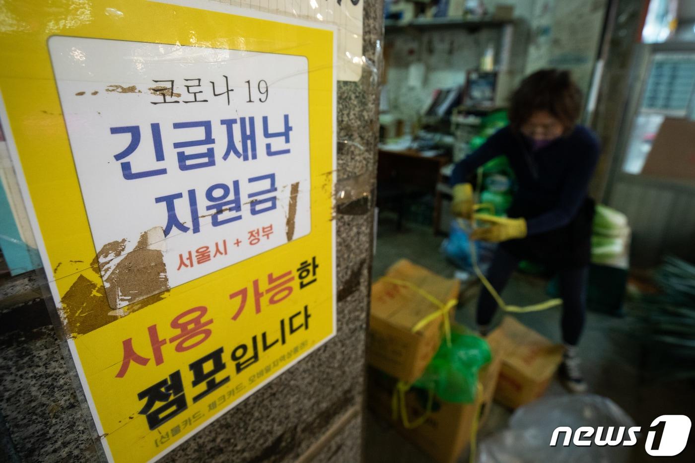 본문 이미지 - 2일 서울시내 한 전통시장에 지난해 재난지원금 지원당시 붙여둔 '긴급 재난지원금 사용가능 점포' 안내문이 붙어 있다. 전국민의 88%에게 1인당 25만원씩 지급되는 상생 국민지원금(5차 재난지원금)은 동네마트나 식당, 편의점 등 소상공인·자영업자 매장에서 주로 사용할 수 있을 전망이다. 지난해 전국민 재난지원금과 마찬가지로 백화점이나 온라인몰, 유흥업종 등에서는 사용이 불가하다. 2021.8.2/뉴스1 ⓒ News1 유승관 기자