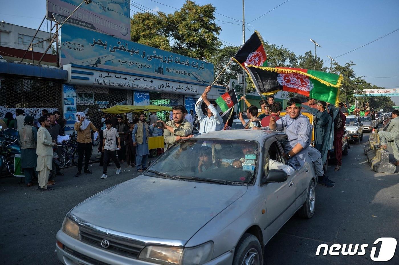 현지시간으로 19일 탈레반이 아프가니스탄을 장악한 카불에서 시민들이 독립 기념일을 맞아 아프간 국기를 들고 차량 시위를 하고 있다. ⓒ AFP=뉴스1 ⓒ News1 우동명 기자