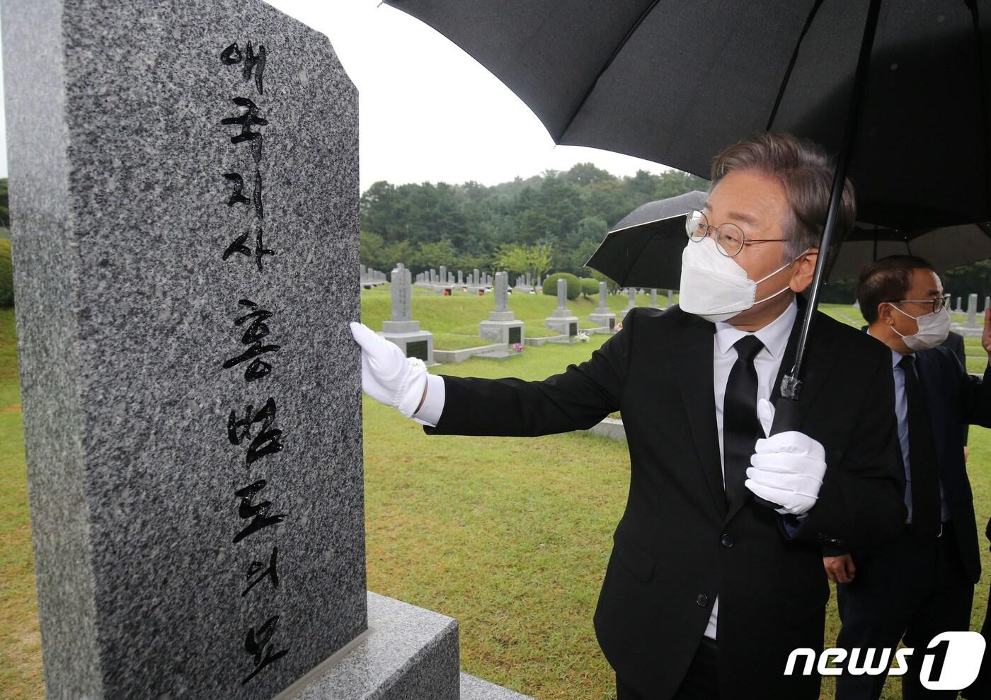 본문 이미지 - 더불어민주당 대선 예비후보인 이재명 경기지사가 21일 국립대전현충원 독립유공자 3묘역에 안장된 홍범도 장군 묘역을 찾아 참배한 뒤 묘비를 어루만지고 있다.  ⓒNews1 김기태 기자