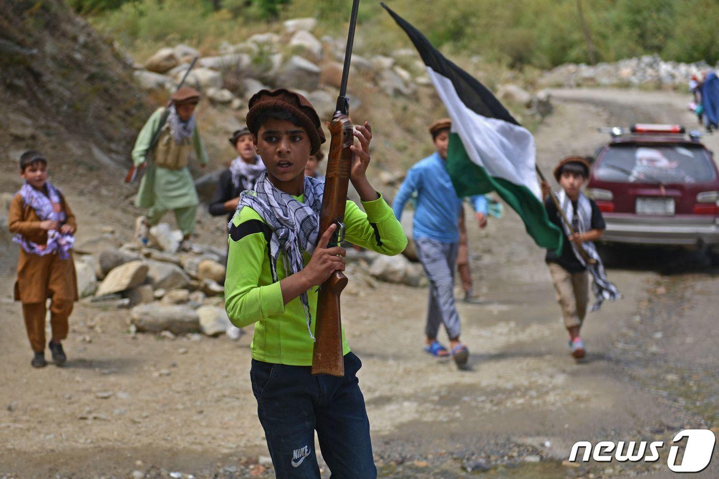 21일 (현지시간) 탈레반이 아프가니스탄을 장악한 뒤 판지시르주 다라에서 아프간 어린이들이 무기와 국기를 들고 있다. ⓒ AFP=뉴스1 ⓒ News1 우동명 기자