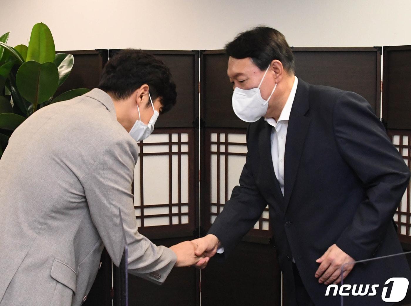본문 이미지 - 윤석열 전 검찰총장이 22일 서울 종로구 국민캠프에서 열린 자영업 비대위 간담회에서 이창호 자영업비대위 공동대표와 악수하고 있다. 2021.8.22/뉴스1 ⓒ News1 오대일 기자