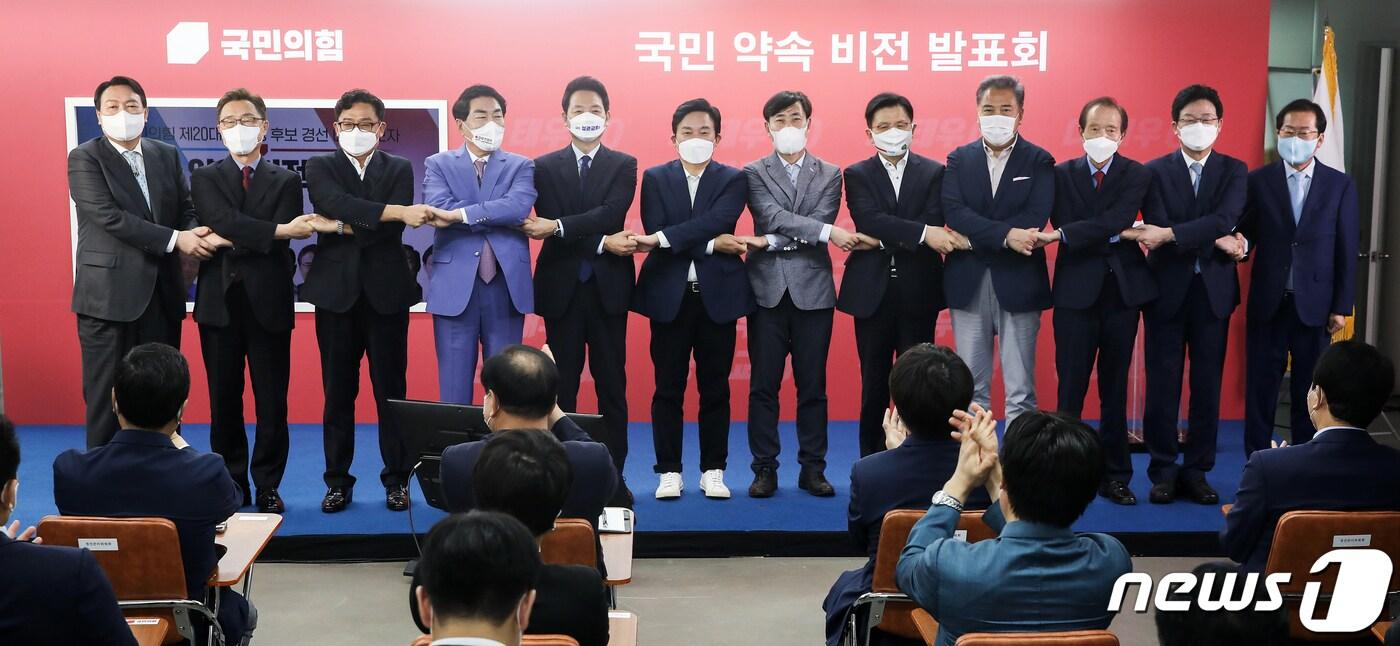 본문 이미지 - 국민의힘 대선 예비후보들이 25일 여의도 당사에서 열린 ‘국민 약속 비전 발표회’에 앞서 손을 맞잡고 기념촬영을 하고 있다. 왼쪽부터 윤석열, 최재형, 박찬주, 안상수, 장성민, 원희룡, 하태경, 황교안, 박 진, 장기표, 유승민, 홍준표 예비후보. 2021.8.25/뉴스1 ⓒ News1 오대일 기자