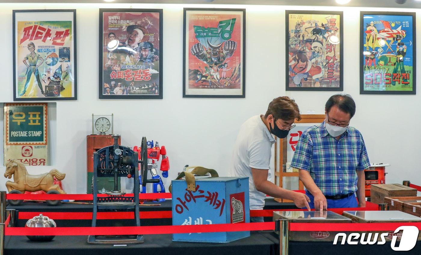 본문 이미지 - 서울 구로구 신도림 문화공간 다락(多樂)에서 열린 '라떼는 말이야' 특별 전시회를 찾은 관람객들이 전시물을 살펴보고 있다. '라떼는 말이야'는 다락(多樂) 개관을 맞아 1970∼80년대 생활용품을 모은 특별전으로 준비됐다. 2021.8.3 ⓒ 뉴스1 민경석 기자
