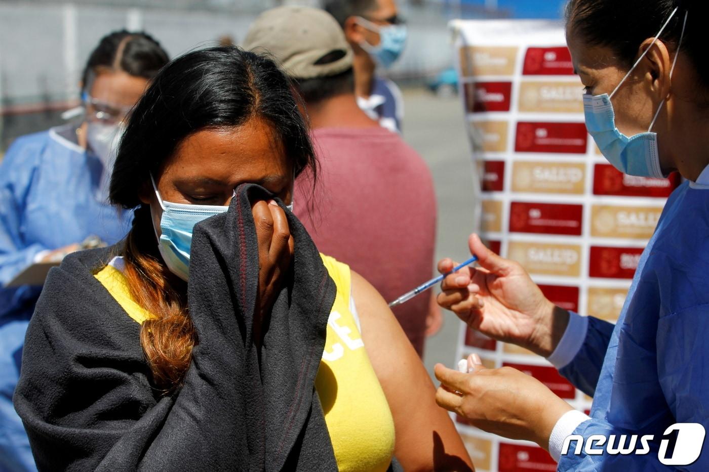 3일(현지시간) 미국과 멕시코 국경인 멕시코 엘 차파랄에서 한 이민자가 미국 의료진으로부터 화이자 백신을 맞고 있다. ⓒ 로이터=뉴스1 ⓒ News1 이정후 기자