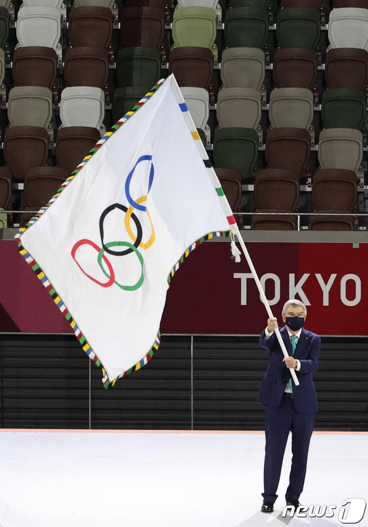 본문 이미지 - 토마스 바흐 국제올림픽위원회(IOC) 위원장이 8일 오후 일본 도쿄 국립경기장에서 열린 '2020 도쿄올림픽' 폐막식에서 오륜기를 흔들고 있다.  2021.8.8/뉴스1 ⓒ News1 이재명 기자