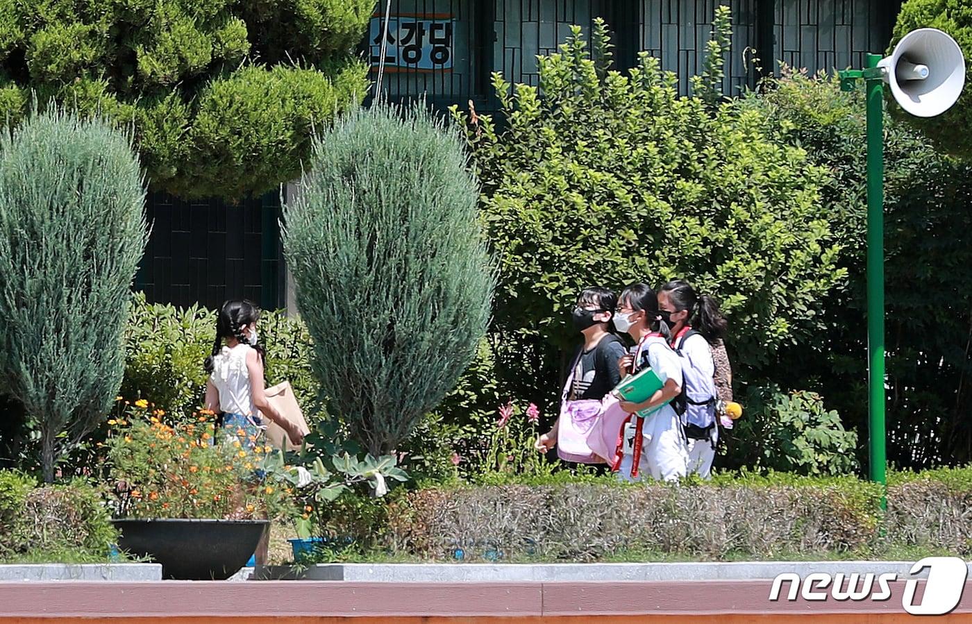 본문 이미지 - 지난 9일 서울 한 초등학교에서 학생들이 온라인 개학식을 마치고 새학기 교과서를 받기 위해 등교하고 있다./뉴스1 ⓒ News1 구윤성 기자