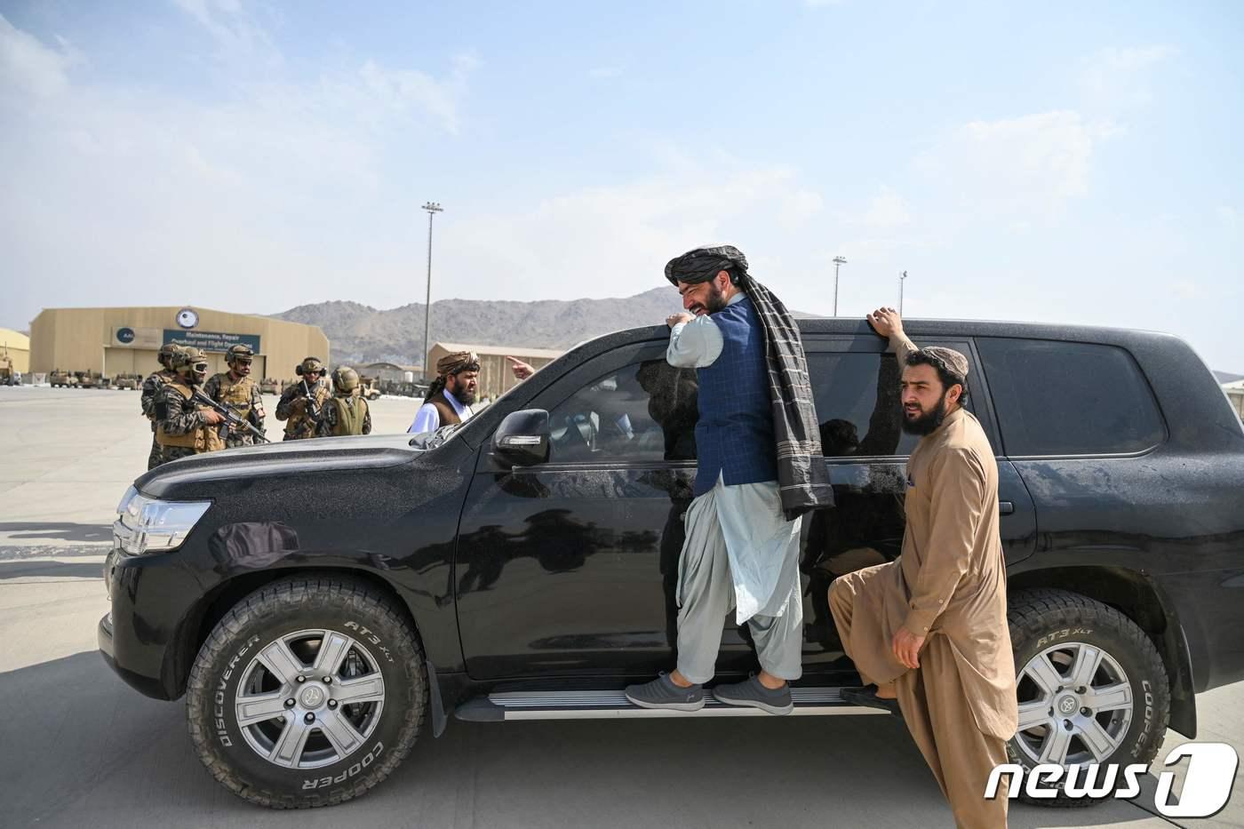 31일(현지시간) 미군이 철수를 완료한 아프가니스탄의 카불 공항에서 탈레반 전사들이 무장 차량 옆에 서 있다. ⓒ AFP=뉴스1 ⓒ News1 우동명 기자