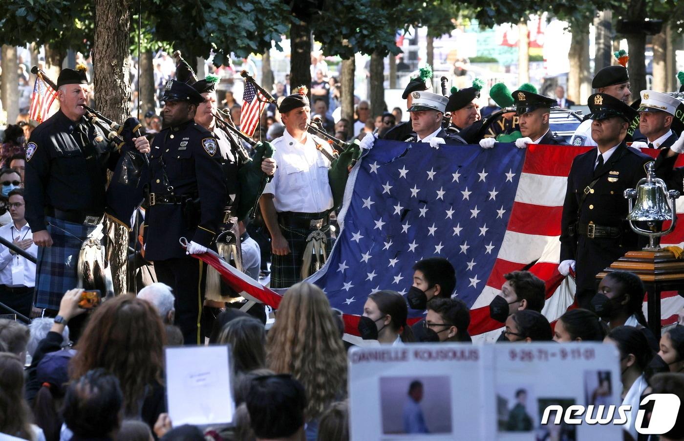본문 이미지 - 뉴욕 경찰 백파이프 팀이 2021년 9월 11일(현지시간) 미국 뉴욕시의 세계무역센터 부지에서 열린 2001년 9월 11일 테러 공격 20주년 기념식에서 세계무역센터의 미국 국기를 들고 서 있다. ⓒ 로이터=뉴스1 ⓒ News1 김현 특파원