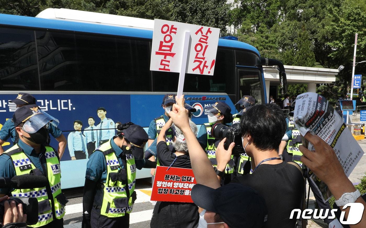 본문 이미지 - '정인이 사건' 2심 첫 정식 재판이 열리는 서울 서초구 서울고등법원 앞에서 시민들이 양부모가 탄 호송차량을 향해 구호를 외치고 있다. 양부모는 정인이의 사망에 고의성이 없었다면서 살인죄를 부인 중이며 1심은 양모와 양부에게 각각 무기징역과 5년형을 선고한 바 있다./뉴스1 ⓒ News1 신웅수 기자