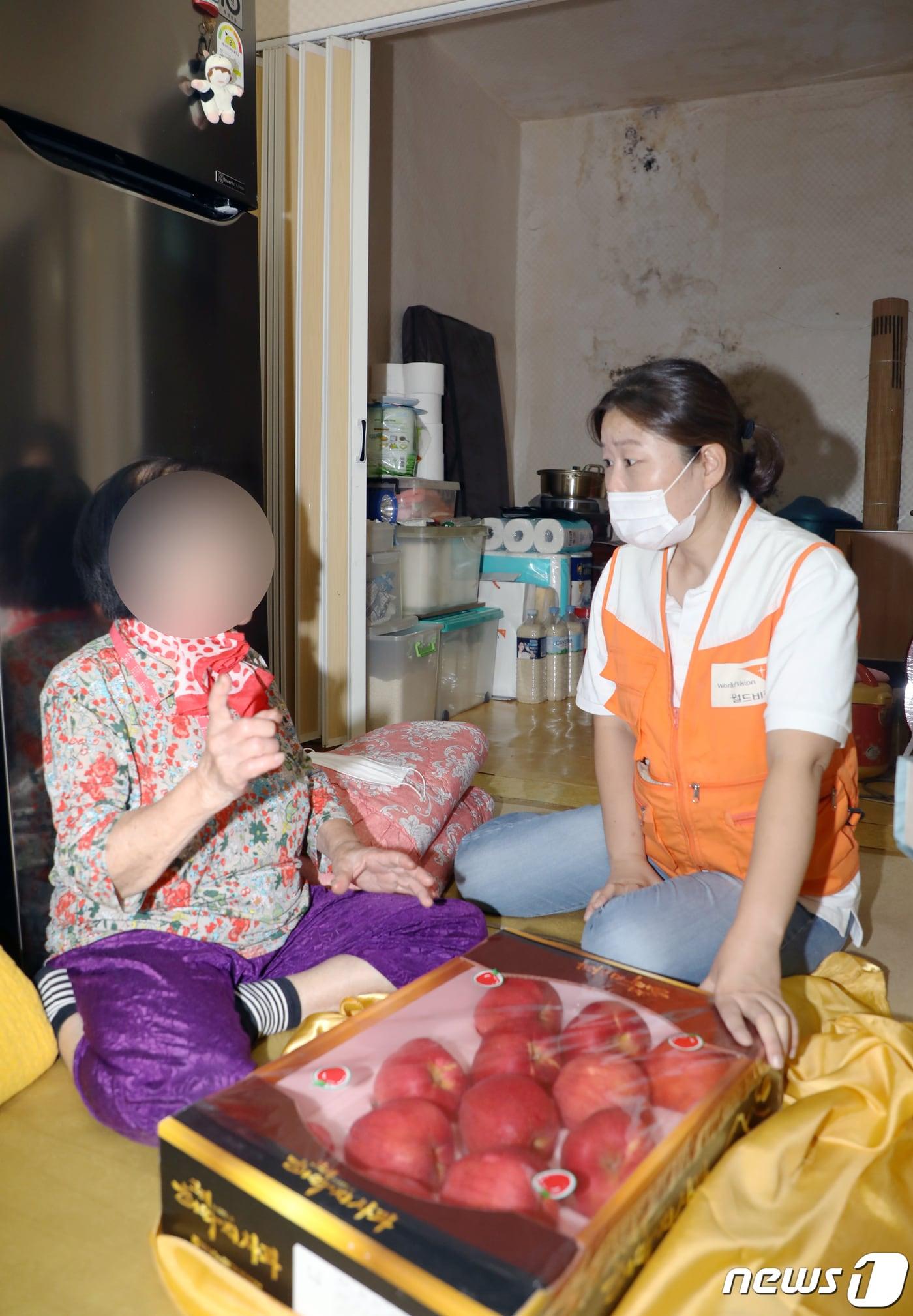 본문 이미지 - 지난 16일 오후 광주 서구 광천동 한 가정에서 이은숙 월드비전 무진종합사회복지관 과장이 독거노인에게 명절 선물 꾸러미를 전달하고 있다. 2021.9.18/뉴스1