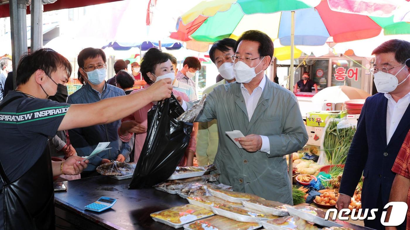 김영록 전라남도지사가 추석 명절을 맞아 19일 순천역전시장을 방문, 순천사랑 상품권으로 주요 성수품을 구매하고 있다. 전남도 공무원의 복지포인트 중 온누리상품권 대체 지급은 5만원에 불과한 실정이다.(전남도 제공) 2021.9.19/뉴스1
