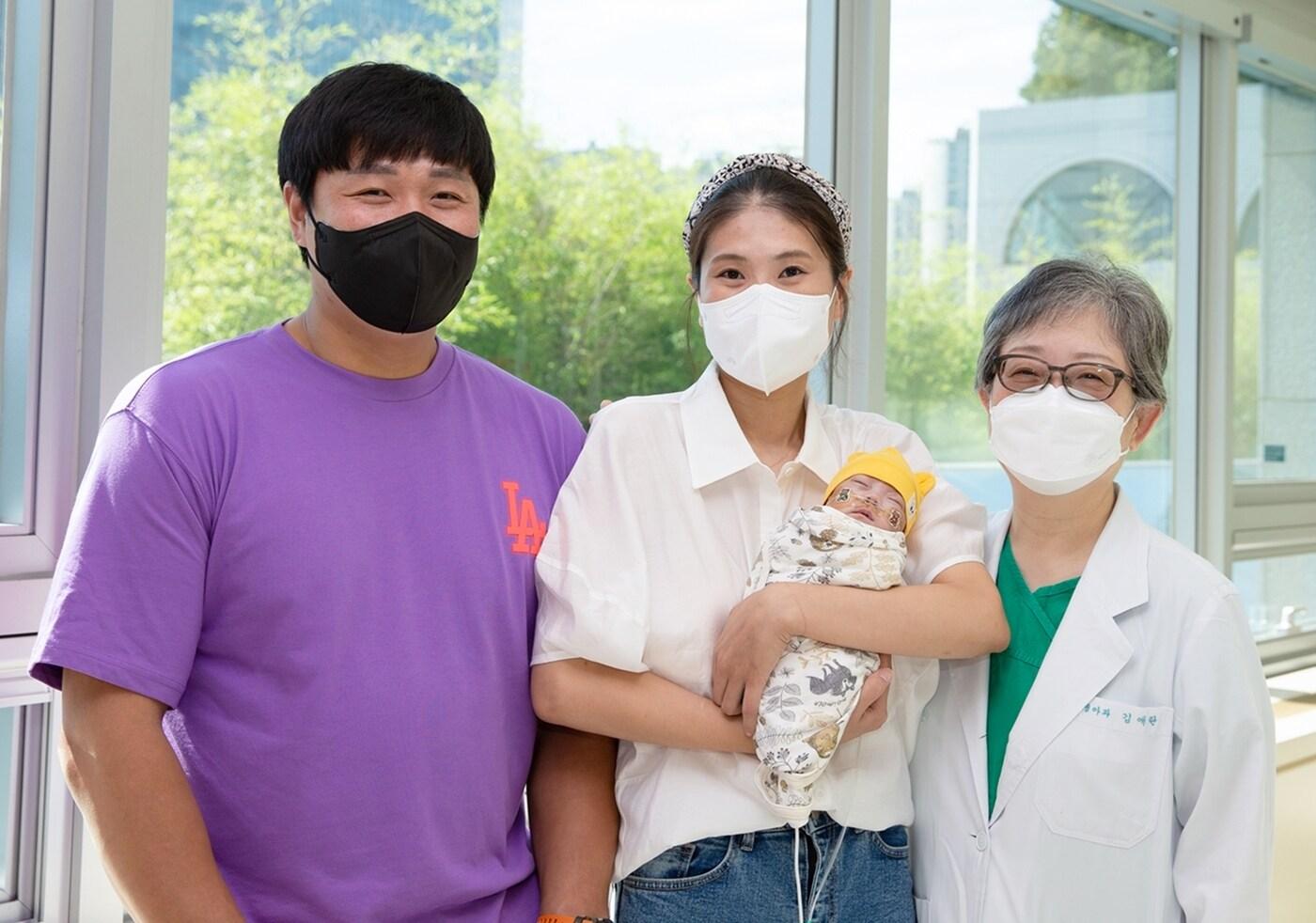 본문 이미지 - 건우 퇴원일인 3일, 건우 부모님이 건우를 품에 안고 주치의인 김애란 서울아산병원 신생아과 교수와 퇴원을 기념하며 사진을 찍고 있다. (서울아산병원 제공)ⓒ 뉴스1