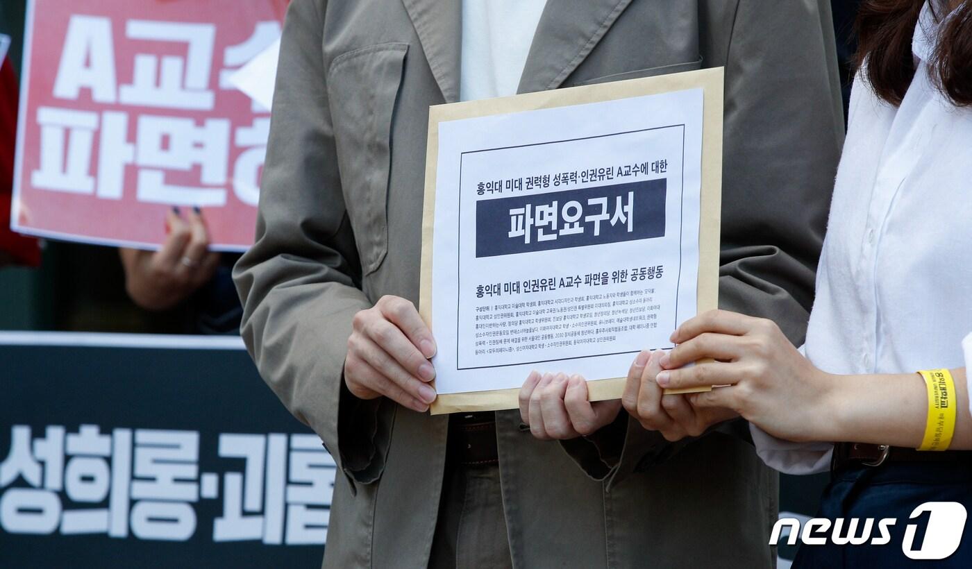 8일 서울 마포구 홍익대학교 앞에서 열린 홍익대 미대 인권유린 A교수 파면 요구 기자회견에서 홍대 학생들이 파면요구서를 들고 있다.  2021.9.8/뉴스1 ⓒ News1 안은나 기자