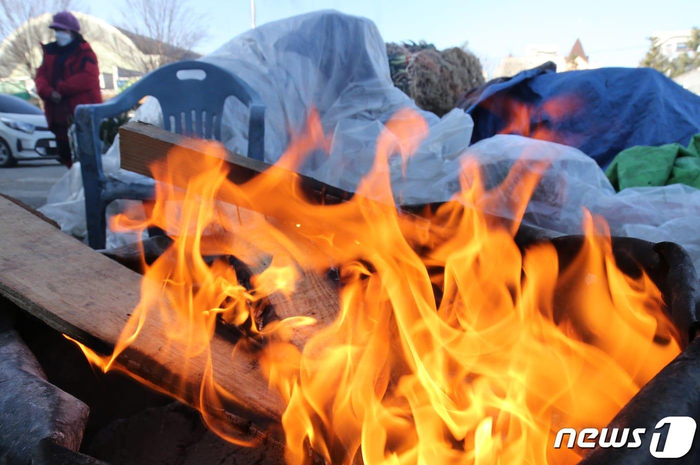 본문 이미지 - 29일 대전·충남은 아침 기온이 -10도 안팎의 강추위가 이어질 것으로 예보됐다. 대전 유성구 노은농수산물시장에서 상인이 모닥불로 추위를 녹이고 있다. /뉴스1 ⓒ News1 김기태 기자