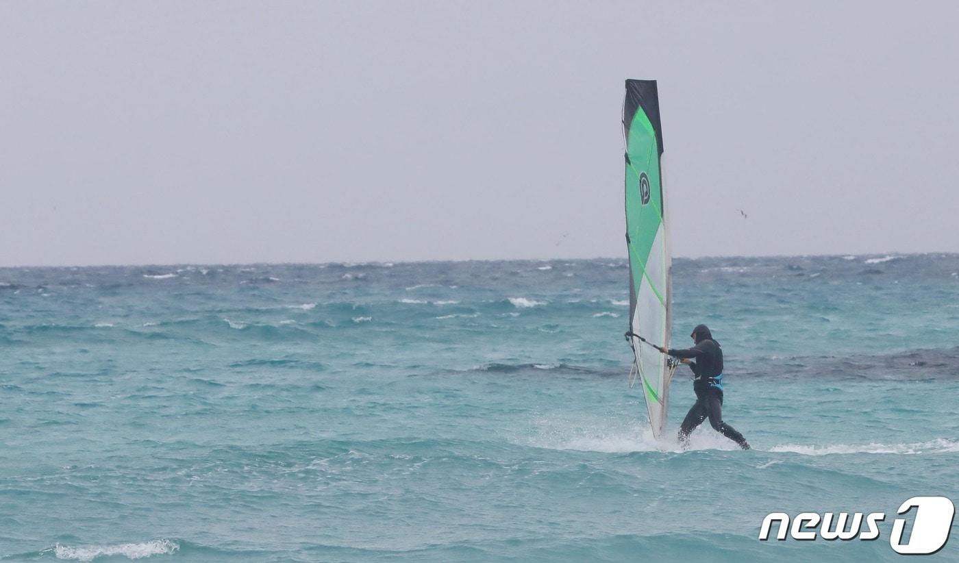 본문 이미지 - 제주시 한림읍 협재해수욕장에서 한 레저객이 겨울 바다에서 윈드서핑을 즐기고 있다ⓒ News1  