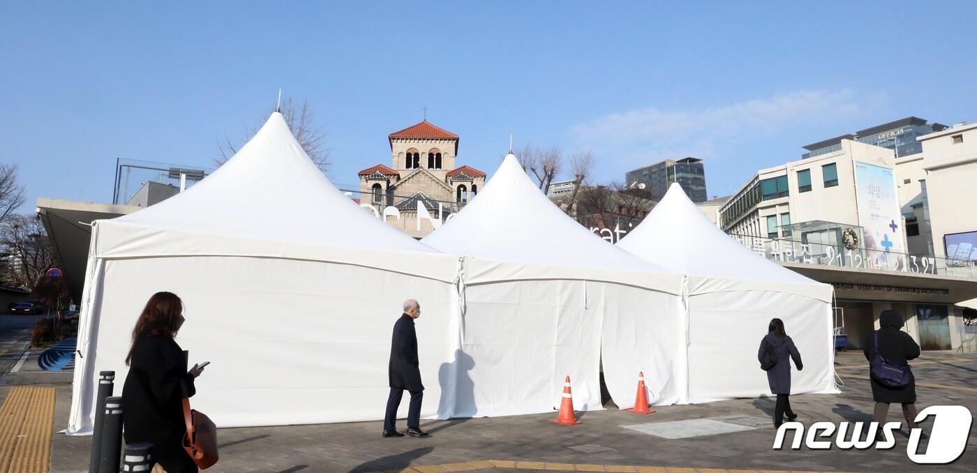 본문 이미지 - 24일 서울시 중구 도시건축전시관에 설치된 백신접종반대 단체의 추모분향소 천막 앞으로 시민들이 걸어가고 있다. 2022.1.24/뉴스1 ⓒ News1 장수영 기자